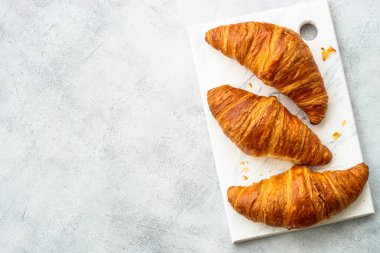 Beyaz masada taze kruvasanlar. Fransız pastanesi. Metin için boşluk olan üst görünüm.