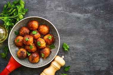 Domates soslu köfte ve karanlık masada otlar. Metin için alanı olan düz resim.