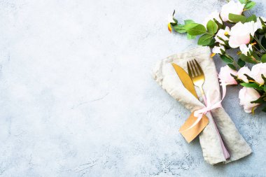 Masa seti, pembe çatal bıçak takımı ve gül çiçekleri. Üst görünüm beyaz ve kopyalama alanı var. Gıda arkaplanı.