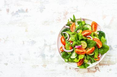 Yapraklı ve sebzeli taze yeşil salata. Arugula, ıspanak, domates ve soğan..