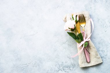 Masa seti, modern çatal bıçak takımı ve gül çiçekleri. Kopyalama alanı olan beyaz arkaplanda üst görünüm.