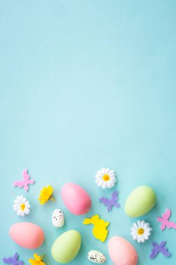 Easter background on blue. Eggs, rabbit, spring flowers and butterfly. Flat lay with copy space. clipart