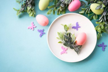 Paskalya sofrası, paskalya yemekleri. Yumurtalı beyaz tabak ve tatil süslemeleri..