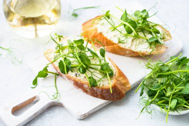 Mavili kızarmış ekmek, yeşil bezelye ve krem peynir. Sağlıklı atıştırmalıklar, vejetaryen. Kapat..