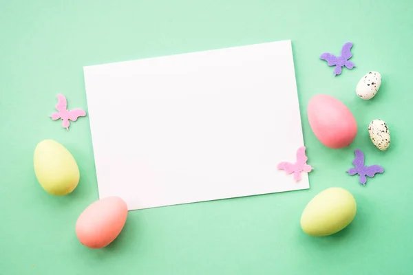 stock image Easter greeting card with eggs and butterflies at color background with empty sheet for your design.