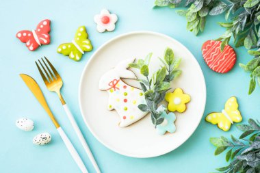 Paskalya sofrası, paskalya yemekleri. Yumurtalı beyaz tabak ve tatil süslemeleri. Kopyalama alanı olan üst görünüm.