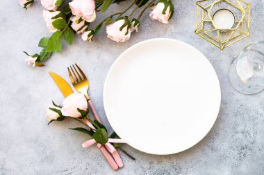 Beyaz tabak ve gül çiçekli Faestive Masa. Yıldönümü ya da düğün için masa dekorasyonu. Kopyalama alanı olan düz.