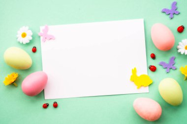 Renkli yumurta, çiçek ve kelebekli Paskalya tebrik kartı. Kopyalama alanı olan düz resim.