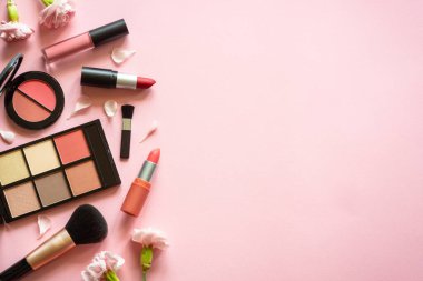 Makeup professional cosmetics on pink background. Flat lay with copy space.