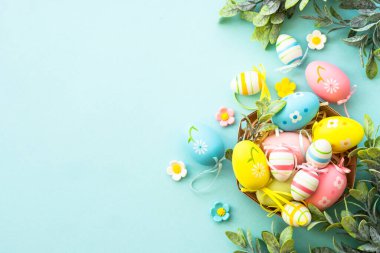 Mavi arka plandaki yuvada paskalya yumurtaları. Paskalya dekoru, tatil geçmişi. Kopyalama alanı olan düz resim.