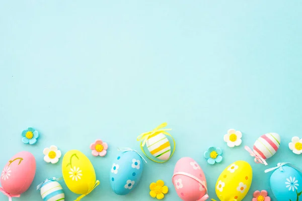 Easter eggs and spring decor on blue background. Flat lay with copy space.