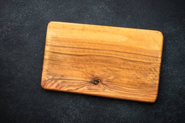 Koyu arkaplanda zeytin kesme tahtası. Üst görünüm.