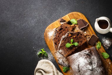Chocolate cake with oranges. Homemade baking. Top view on black.