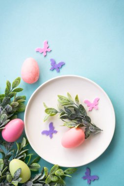 Paskalya sofrası, paskalya yemekleri. Yumurtalı beyaz tabak ve tatil süslemeleri..