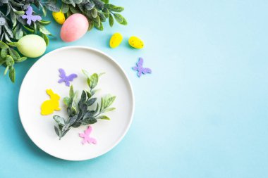 Paskalya yemeği geçmişi. Yumurtalı beyaz tabak, bahar çiçekleri, yeşil yapraklar ve kelebekler. Düz yatıyordu.