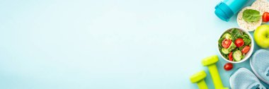 Sağlıklı yaşam tarzı ve diyet gıda geçmişi. Spor ayakkabılar, dambıl ve mavi üzerine sağlıklı yiyecekler. Kopyalama alanı olan düz.
