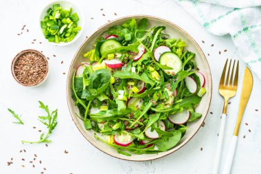 Ispanaklı yeşil salata, roka ve zeytinyağlı turp. Beyaz üzerine üst görünüm.