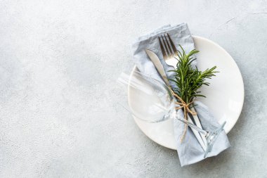 Masa ayarı, beyaz servis. Beyaz tabak, çatal bıçak takımı ve cam şarap. Düz görünüm.