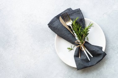 Masa beyaza ayarlandı. Beyaz tabak, çatal bıçak takımı ve biberiyeli peçete. Kopyalama alanı olan düz resim.