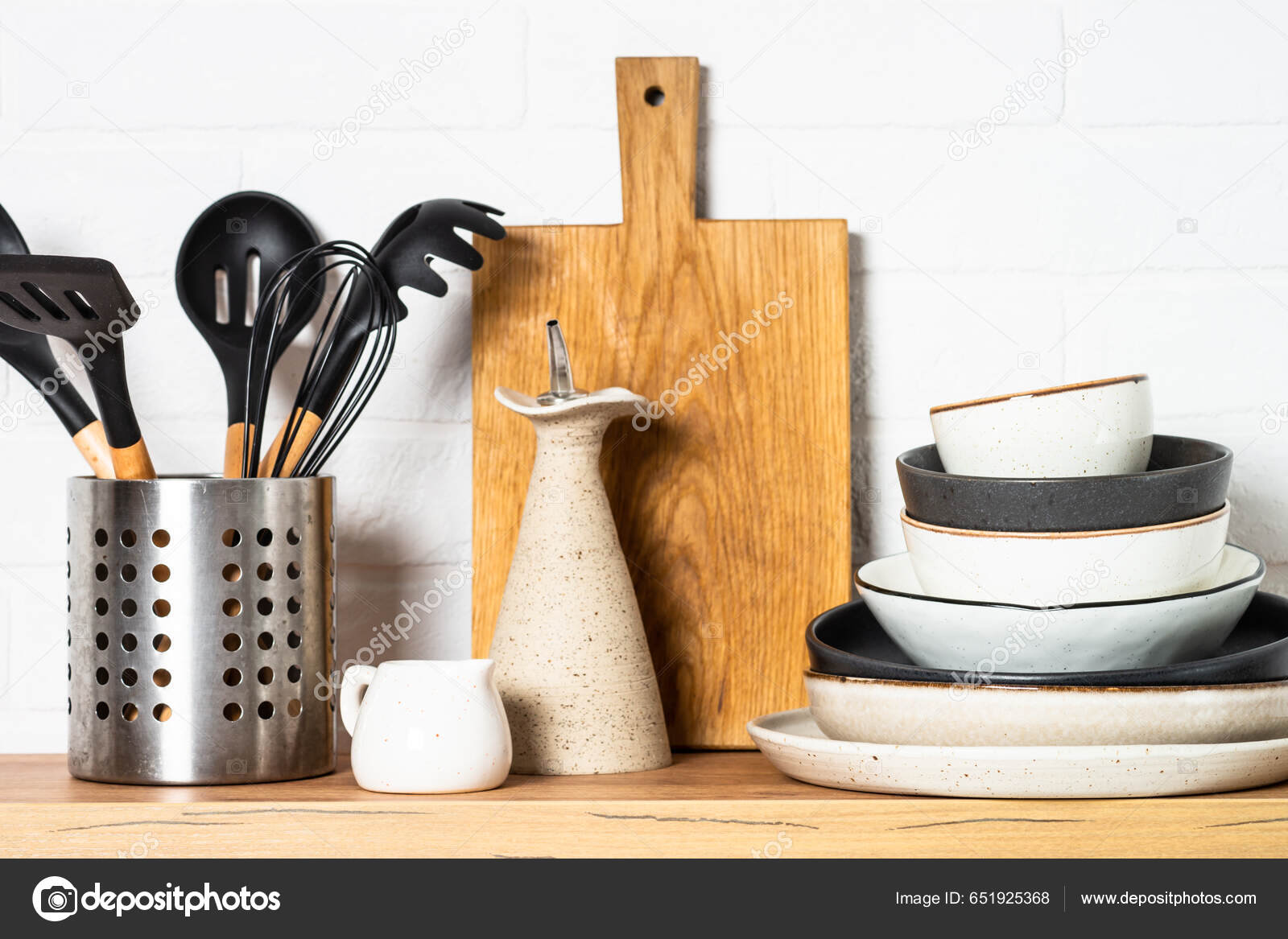 Cooking tools with wooden cutting boards, oil and shaker at white modern  kitchen interior. Stock Photo by Nadianb