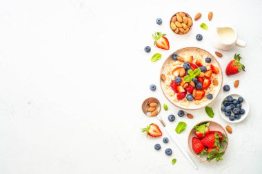 Beyaz arka planda taze böğürtlen ve fındıklı yulaf ezmesi. Sağlıklı kahvaltı, fotokopi alanı olan üst manzara.
