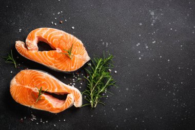 Çiğ balık, siyah arka planda taze somon bifteği..