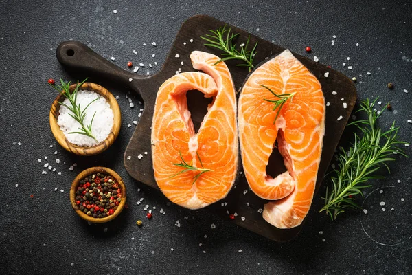 鲑鱼排在黑色背景的木板上 烹饪配料的顶视图 — 图库照片