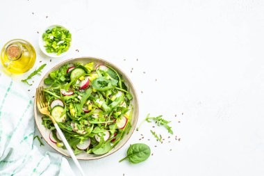 Ispanaklı yeşil salata, roka ve beyaz masada zeytinyağı ile turp. Kopyalama alanı olan üst görünüm.