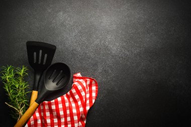 Kitchen utensils with food ingredients on black. Food background. Top view with copy space.