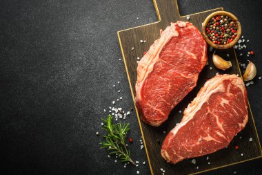 Beef steak. Raw beef meat at black. Top view with copy space.