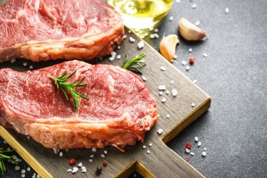 Beef steak with spices. Raw beef meat at cutting board. Close up.
