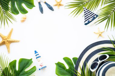 Yaz düzlüğü arka plandaydı. Yaz tatili ve seyahat konsepti. Palmiye yaprakları, deniz kabukları ve beyaz arka planda dekor.