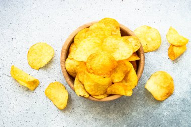 Beyaz masada tahta kasede patates cipsi. Üst görünüm.