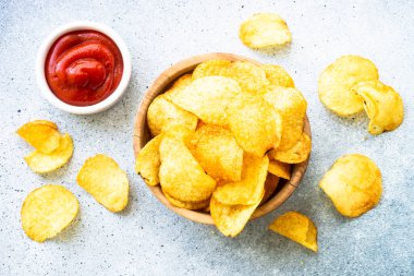 Beyaz masada patates cipsi ve ketçap sosu. Üst görünüm.