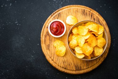 Beyaz masada patates cipsi ve ketçap sosu. Kopyalama alanı olan üst görünüm.
