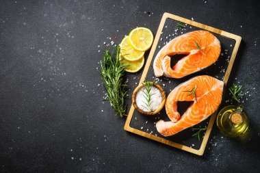 Siyah arka planda somon balığı taze somon bifteği. Kopyalama alanı olan üst görünüm.