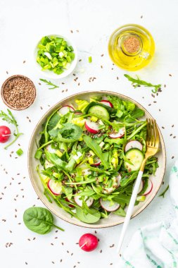 Ispanaklı yeşil salata, roka ve beyaz masada zeytinyağı ile turp. Kopyalama alanı olan üst görünüm.