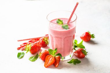 Beyaz masada taze böğürtlenli çilekli içecek ya da milkshake..