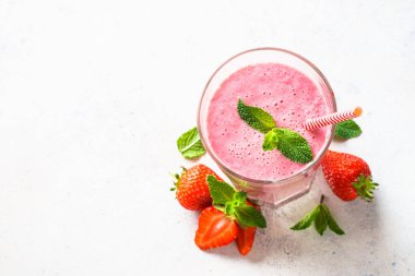 Çilekli smoothie ya da beyaz masada bardakta milkshake. Üst görünüm.