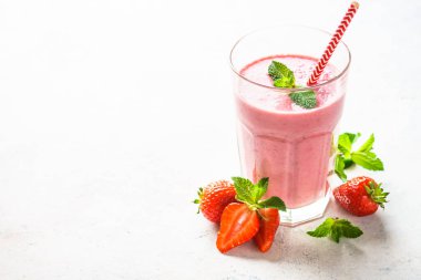 Beyaz masada çilekli smoothie veya milkshake.