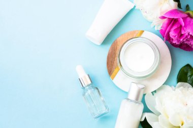 Natural cosmetic products. Cream, serum, tonic with green leaves and flowers. Skin care concept.