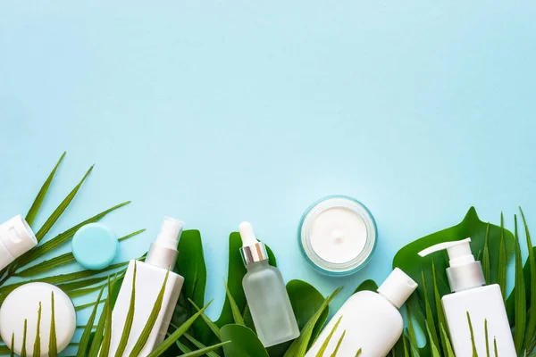 天然化粧品 クリーム 緑の熱帯の葉と強壮剤 デザインのためのスペースと青の背景にフラットレイアウト — ストック写真