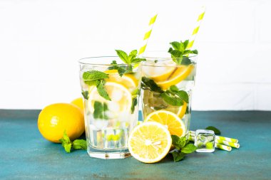 Limonata bardakta beyaz masada taze limon ve nane ile. Soğuk yaz içeceği.