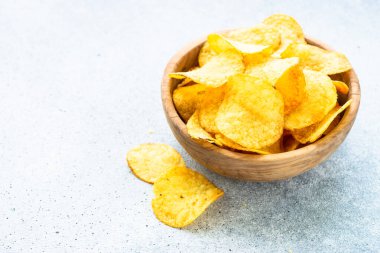 Beyaz masada tahta kasede patates cipsi. Kopyalama alanı olan üst görünüm.