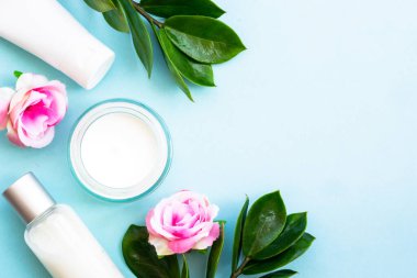 Natural cosmetic products. Cream, serum, tonic with green leaves and flowers. Skin care concept.