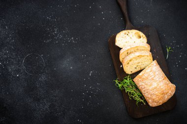 Ciabatta ekmeği tahtada, siyah arka planda. Kopyalama alanı olan üst görünüm.