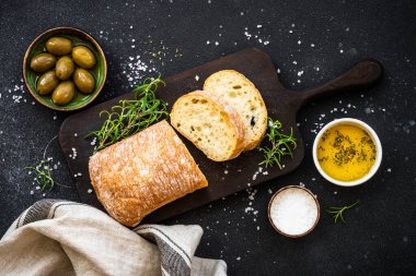 Ciabatta ekmeği, zeytinyağı, zeytin ve siyah otlar. Akdeniz yemekleri. Üst görünüm.
