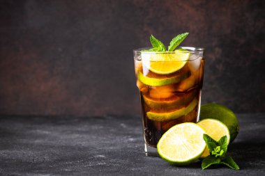 Küba Libre alkollü kokteyli, koyu arkaplanda buzlu içecek..
