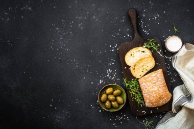 Ciabatta ekmeği, zeytinli ve siyah otlu. Akdeniz yemekleri. Kopyalama alanı olan üst görünüm.