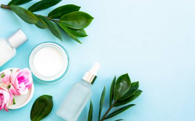 Natural cosmetic products. Cream, serum, tonic with green leaves and flowers. Skin care concept.